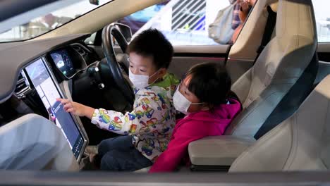 Junge-Besucher-Testen-Einen-Tesla-Model-X-Central-Touchscreen-Auf-Dem-Amerikanischen-Stand-Für-Firmenwagen-Von-Tesla-Motors-Während-Der-International-Motor-Expo,-Auf-Der-Ev-Elektroautos-In-Hongkong-Vorgestellt-Werden