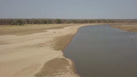 Antenne:-Mutter-Und-Babyelefant-Laufen-Auf-Einer-Wattfläche-In-Der-Nähe-Des-Afrikanischen-Flusses