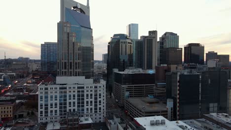 Aerial-view-of-tall-buildings-and-the-Broadway-street-in-Nashville-city,-USA---tracking,-drone-shot