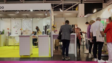 Slow-motion-shot-of-people-and-businessman-with-face-mask-shopping-on-trade-fair-during-covid-19-pandemic-in-2022