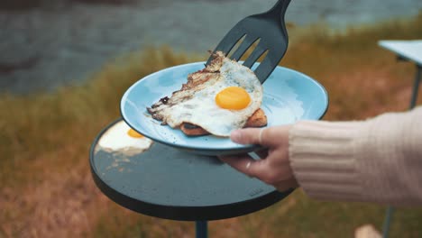 Placing-Eggs-Baked-On-a-Sheet-Pan-on-toasted-bread-whilst-camped-by-a-lake