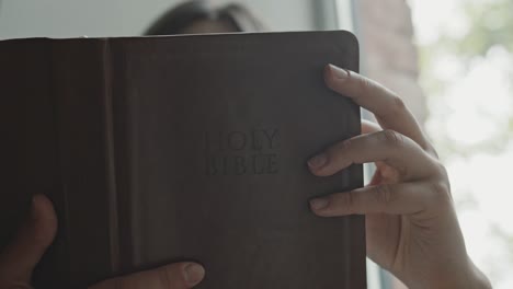 Woman-reading-the-holy-bible,-studying-the-catholic-sacred-text,-believer-of-the-catholic-faith