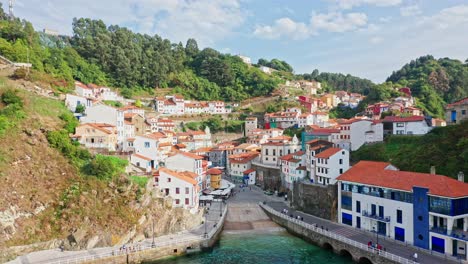 Scenic-aerial-view-of-Cudillero,-Spanish-coastal-picturesque-fishing-village-while-seagulls-fly