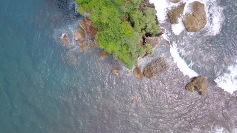 Aerial-top-down-view-natural-landscape-ocean-waves-splashing-in-a-beach-in-Indonesia,-Southeast-Asia