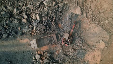 Aerial-zoom-in-drone-shot-of-excavator-loading-rocks-and-soil-on-the-truck-in-India