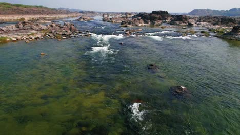 Aerial-forwarding-shot-of-river-valley-with-Narmada-river-flowing-in-Vadodara,-India-over-bright-sunny-day