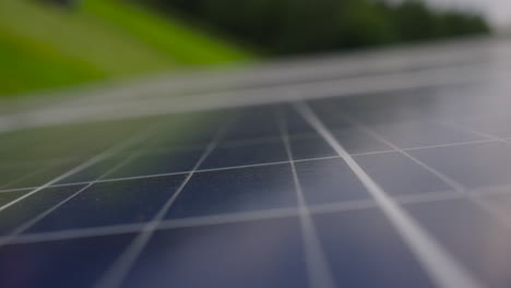 Nahaufnahme-Nach-Unten-Schwenkende-Ansicht-Des-Photovoltaischen-PV-Solarmoduls-Im-Feld,-Ökologie-Null-Emissions-Technologie,-Schöner-Unscharfer-Defokussierter-Hintergrund