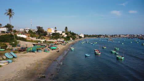 Pescador-En-La-Costa-Reparando-El-Barco-De-Pesca-Tradicional-Coracle,-Mui-Ne,-Vietnam