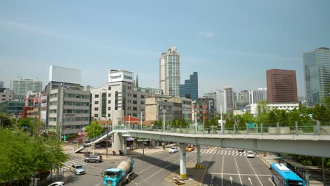 Pedestrians-at-Seoullo-7017-skygarden-park-walkway-over-the-Seoul-and-cars-traffic-under-the-overpass,-South-Korea-city-streets-with-high-rise-buildings