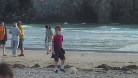 Kleiner-Junge-Spielt-Mit-Seinem-Fußball-Am-Strand-Von-Perranporth,-Cornwall,-England