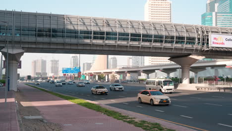 Cars-on-the-famous-Sheikh-Zayed-Road-in-Dubai,-Metro-overwalk-bridge