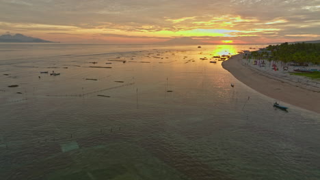 Sunrise-at-Pantai-Pasir-Putih-point-on-Nusa-Lembongan-island,-aerial