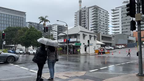 Outdoor-street-view-capturing-pedestrians-road-crossing-and-car-traffics-at-junction-between-Melbourne-and-Edmondstone-street-on-a-rainy-day,-South-Brisbane,-Queensland,-Australia,-establishing-shot