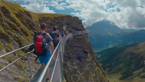 People-walking-across-the-first-cliff-walk-in-Grindelwald,-Switzerland