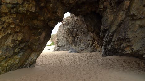 Hollow-Cave-in-Gruta-da-Adraga-on-a-Sandy-Beach