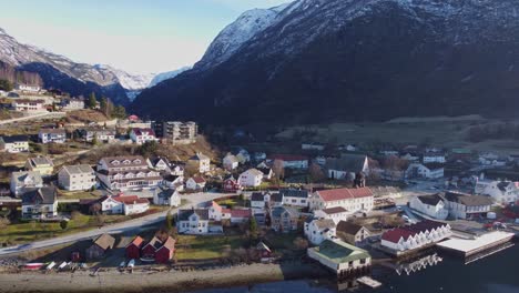 Beautiful-Aurlandsvangen-town-center-in-Sogn-Norway---Sunny-scenic-morning-aerial-with-snow-capped-mountains-in-background