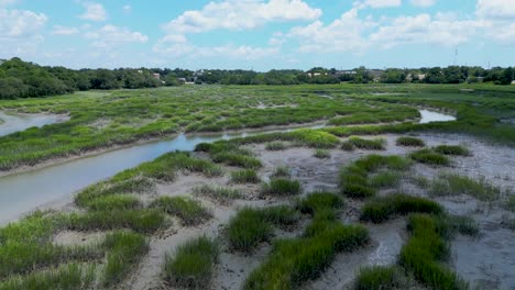 Slow-rise-and-away-aerial-shot-over-a-marsh-on-a-sunny,-summer-day-in-South-Carolina