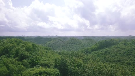 Drone-shot-over-the-green-forest-covered-hills-in-cloudy-sky