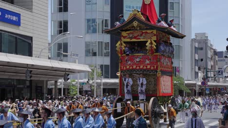 Japanische-Männer-Tragen-Einen-Riesigen-Tragbaren-Yamaboko-schrein-Durch-Die-Straßen