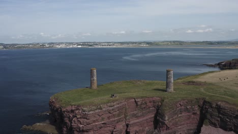 Aerial-retreats-from-sea-cliffs-and-nautical-towers-at-Brownstown-Head