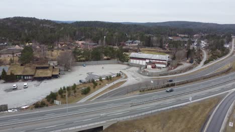 Aerial-above-highway-E18-in-Kristiansand-while-looking-towards-entrance-and-fencing-of-Dyreparken-zoo---Norway