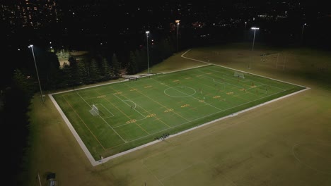 Aerial-zoom-in-of-a-night-time-soccer-or-football-game-outdoor