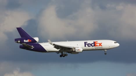 Tracking-Shot-FedEX-MD-11F-Cargo-Freighter-Approaching-the-Airport-with-Clouds-in-the-Background