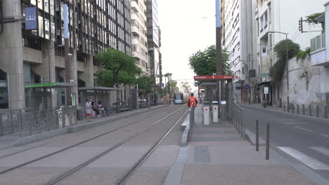 Tramway-train-in-Casablanca-that-stops-at-a-station-on-the-end-of-Hassan-II-Avenue,-fixed-camera-shot