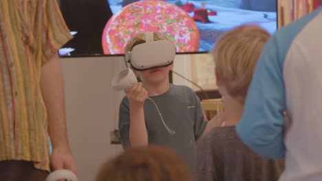 Kleiner-Junge-Passt-Virtual-Reality-Headset-An,-Während-Andere-Kinder-Ihn-In-Einem-Klassenzimmer-Beobachten