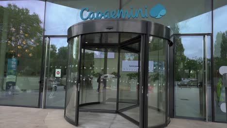 Rotating-door-of-Capgemini's-147-building-with-logo-above,-view-of-the-interior-of-the-office-building,-fixed-front-shot
