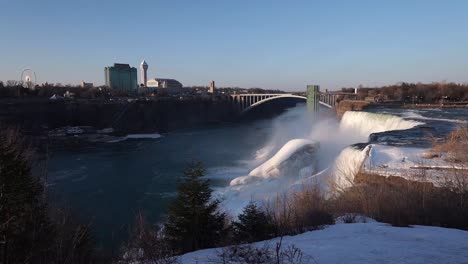 Niagara-Falls-With-Rainbow-International-Bridge-At-Winter-In-Ontario,-Canada