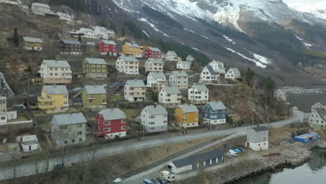 Luftaufnahme,-Die-Auf-Die-Farbenfrohen-Häuser-In-Der-Kleinen-Stadt-Odda-In-Norwegen-Zufliegt,-Die-Direkt-Neben-Einem-Fjord-Liegt