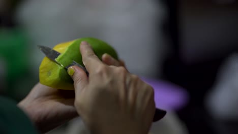 4k-Eine-Person,-Die-Mango-Mit-Einem-Messer-In-Einer-Küche-Schält