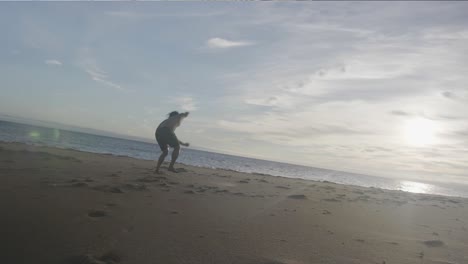 Dancer-on-beach-low-angle-doing-jump