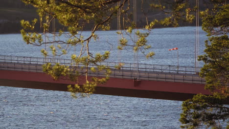 Cars-driving-over-a-swedish-bridge,-in-the-archipelago,-at-a-sunny-day,-at-Hoga-Kusten,-Vasternorrland,-Sweden