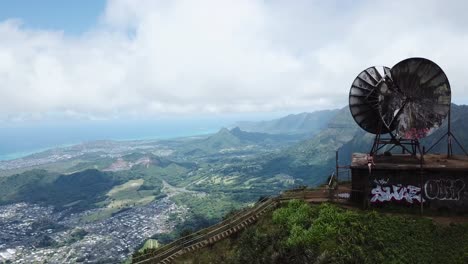 Drone-4000ft-up-in-the-air-in-Oahu-getting-a-shot-of-a-Satellite-on-top-of-the-Stairway-to-Heaven,-a-girl-is-sitting-on-the-satellite-as-the-shot-reveals-a-different-angle