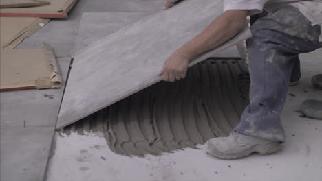 Man-installing-big-ceramic-floors-on-the-outside-of-the-home,-in-4k-slowmotion
