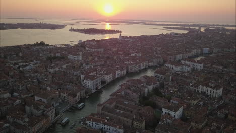 Aerial-shot-flying-towards-sunrise-and-Cannaregio-area-over-Canal-Grande-,-Venice,-Italy