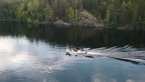 Un-Grupo-De-Adultos-En-Un-Bote-Que-Atraviesa-Un-Lago-Tranquilo-En-Lakeland-Finlandia