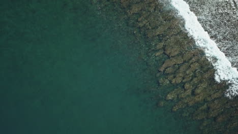 drone-shot-in-bird's-eye-view,-going-forward-above-the-reef-and-the-waves-in-Mauritius-island