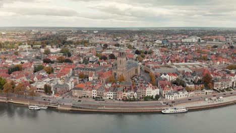Aerial-drone-shot-closing-in-on-the-Dutch-medieval-city-of-Deventer-from-a-high-altitude-showing-the-whole-city-starting-from-the-other-side-of-the-river-IJssel-in-The-Netherlands