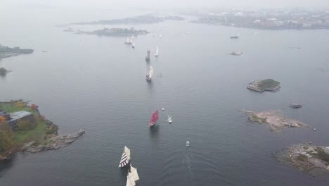 Aerial-footage-of-tradtional-wooden-sailing-ships-sailing-in-front-of-port-of-Helsinki-Finland