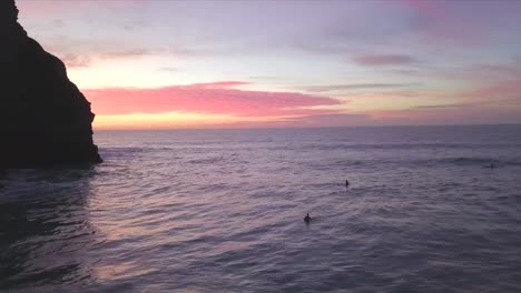 Klippensilhouette-Und-Surfer,-Die-Bei-Sonnenuntergang-In-Cornwall-Surfen