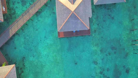 Aerial-flight-over-clear-turqoise-ocean-and-floating-village-in-Mabul,-Malaysia