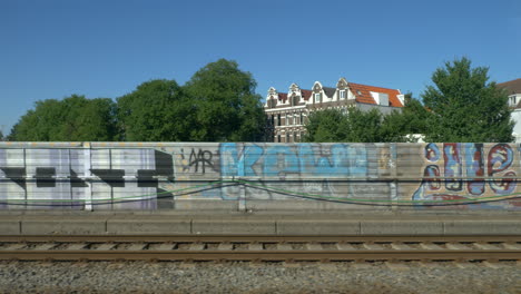 Travelling-to-the-side-of-the-rail-and-the-houses-in-backgroud,-Amsterdam,-Netherlands