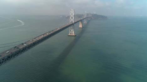 Aerial-shot-of-vehicles-moving-on-San-Francisco–Oakland-Bay-Bridge-with-city-in-background