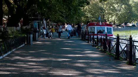 Family-walking-just-next-to-the-lake-of-Ioannina-in-Greece