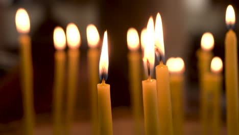 Ein-Paar-Brennende-Kerzen-In-Der-Griechisch-orthodoxen-Kirche-Von-Madaba-St-George-Mit-Vielen-Weiteren-Kerzen,-Die-Im-Hintergrund-Verschwommen-Sind