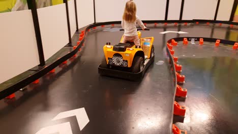 funny-clip-of-girl-casually-riding-toy-car-at-indoor-amusement-park