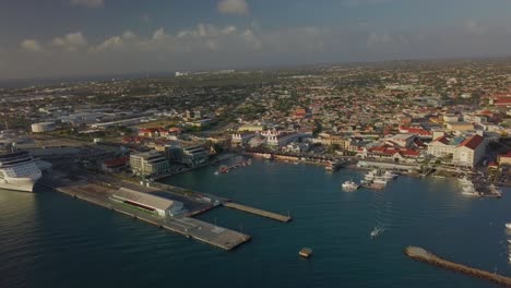 Aerial-view-of-a-beautiful-marina-and-busy-streets-next-to-the-marina-with-the-island-in-the-background-4K